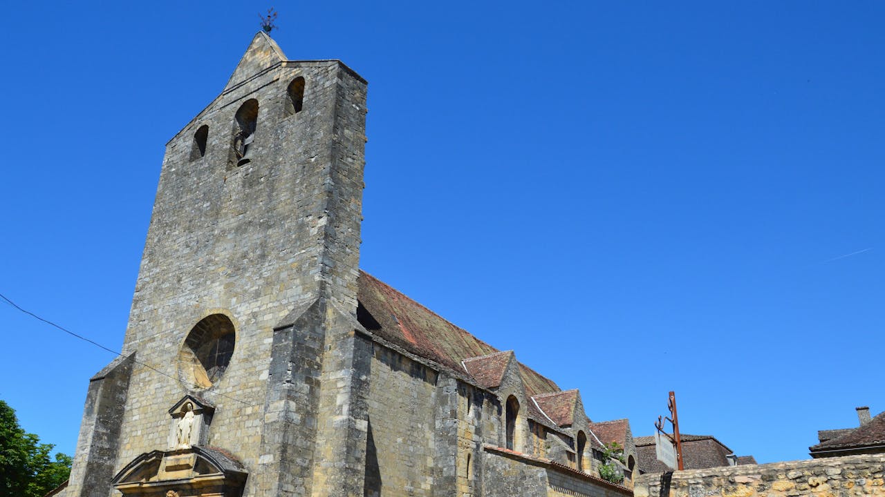 A Romanesque church showcasing stone architecture under a clear blue sky.